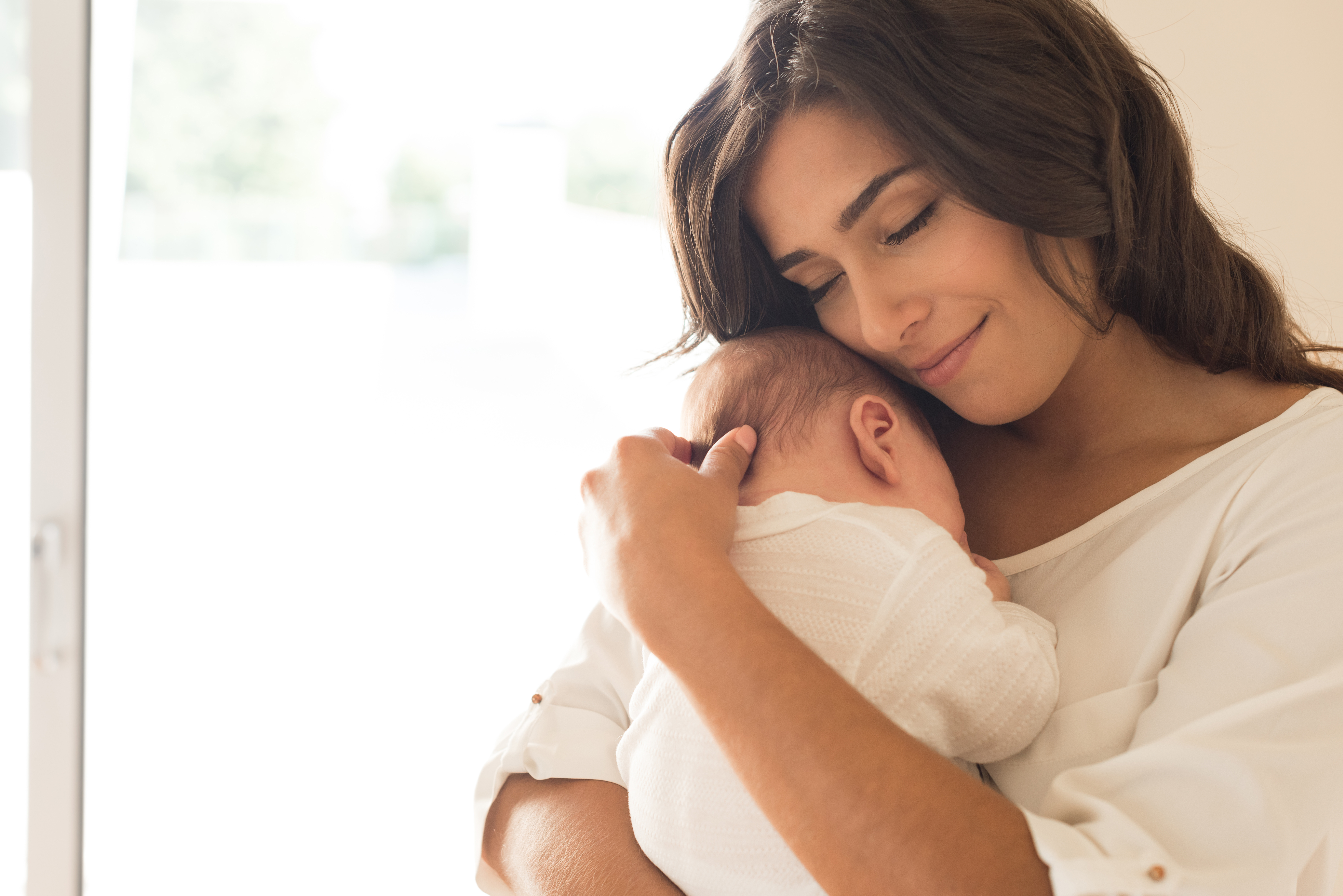 mother holding her newborn baby calmly in the early weeks after birth